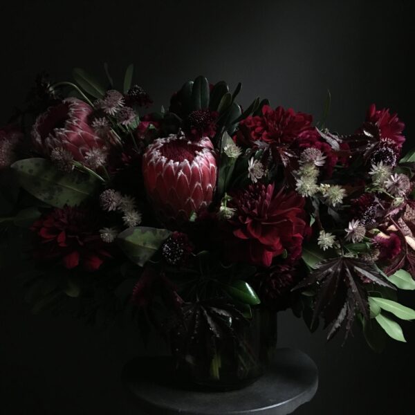 Amorous Floral design. This opulent bouquet, drenched in the deeper shades of burgundy, serves as a powerful symbol of profound and intense emotions.