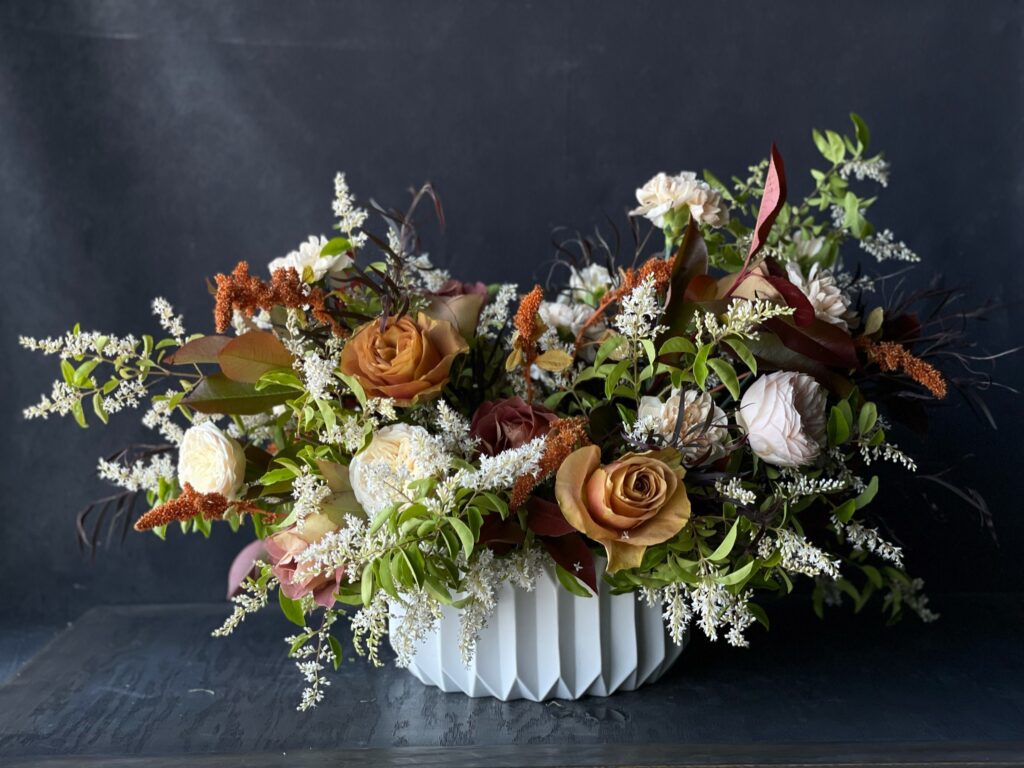 Classic, lush mixed flower arrangement in low ceramic vase.