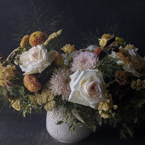 Classic, lush mixed flower arrangement in low ceramic vase.