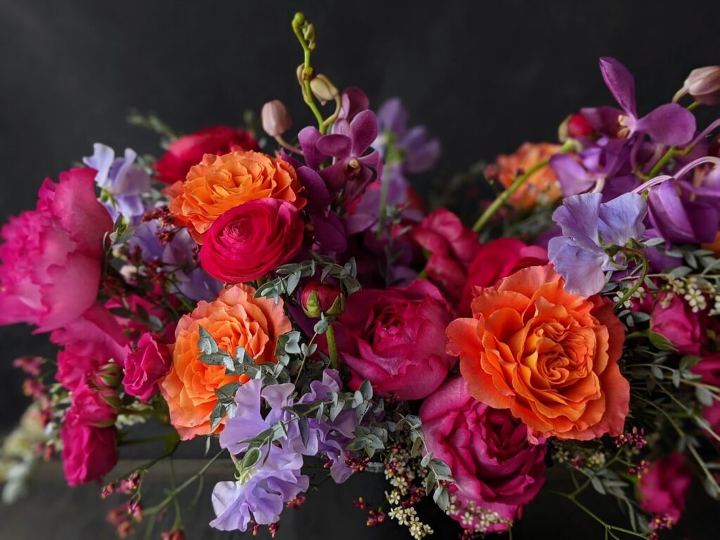 Classic, lush mixed flower arrangement in low ceramic vase.